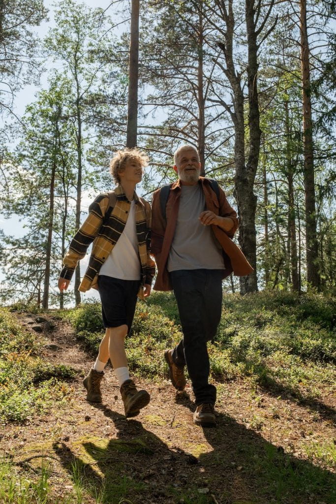 grandfather and grandson walking in a forest