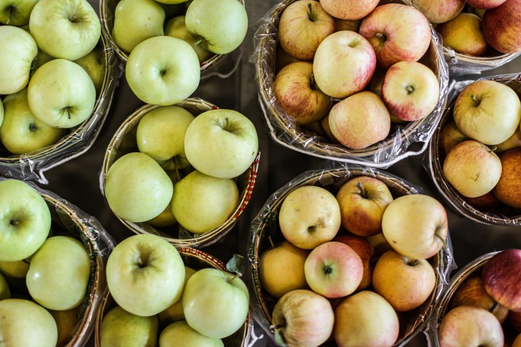 green and red apples on brown woven basket